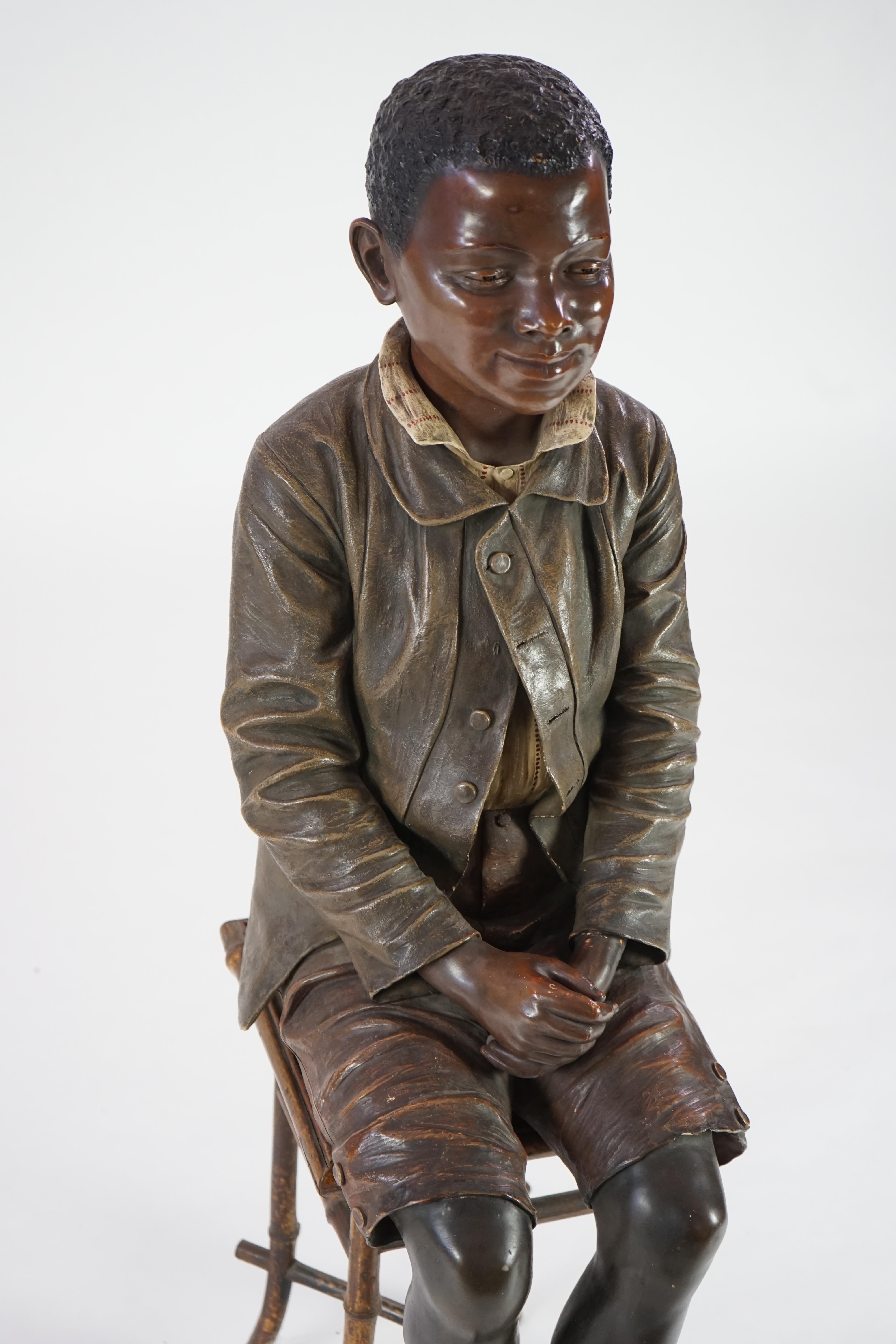 A late 19th century Friedrich Goldscheider life size cold painted terracotta figure of a black boy